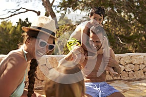 Family On Vacation Having Fun By Outdoor Pool