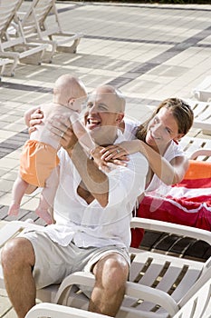 Family vacation, relax on pool deck lounge chairs