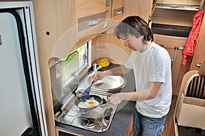 Family vacation, RV holiday trip, travel and camping, man cooking in camper interior