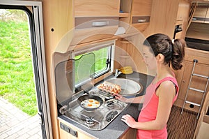 Family vacation, RV holiday trip, travel and camping, woman cooking in camper, motorhome interior photo