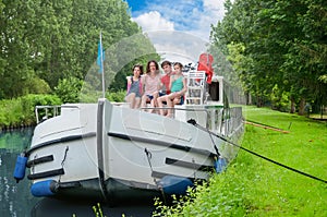 Family vacation, summer holiday travel on barge boat in canal, happy kids and parents having fun on river cruise trip in houseboat