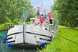 Family vacation, summer holiday travel on barge boat in canal, happy kids and parents having fun on river cruise trip in houseboat