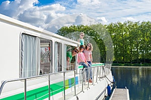 Family vacation, summer holiday travel on barge boat in canal, happy kids and parents having fun on river cruise trip in houseboat