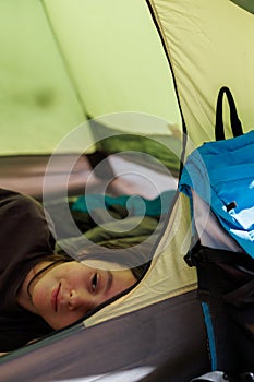 family vacation and travel. joyful boy lies in a tent. travel with children. hiking in the forest and living in a tent