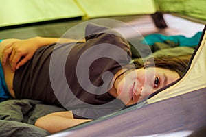 family vacation and travel. joyful boy lies in a tent. travel with children. hiking in the forest and living in a tent