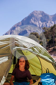 family vacation and travel. joyful boy sits in a tent. travel with children. hiking in the forest and living in a tent