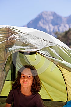 family vacation and travel. joyful boy sits in a tent. travel with children. hiking in the forest and living in a tent