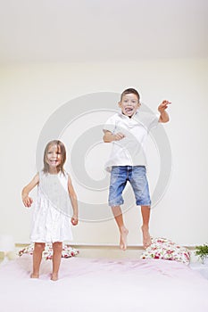 Family Values and Relationships. Happy Kids Playing Indoors. Jumping On The bed Together.