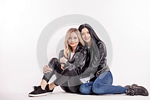 Family values. two female rockers are sitting on the floor and posing to camera