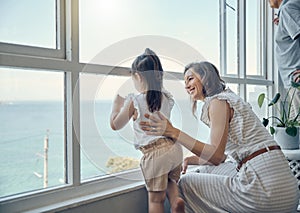 Family view, window and mother with child bonding, having fun and enjoy quality time together in home living room. Mamas