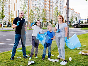 A family of volunteers cleaning up garbage and plastic on the territory of a residential complex. The concept of