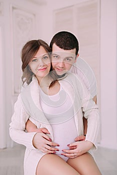 Family waiting for baby`s birth. A pregnant woman and her husband wearing white clothing