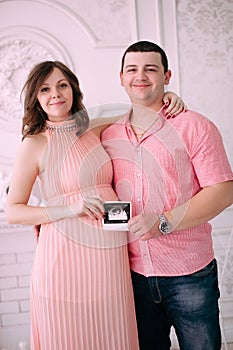 Family waiting for baby`s birth. A pregnant woman and her husband wearing white clothing