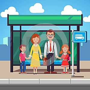 Family waiting for transit on a city bus stop