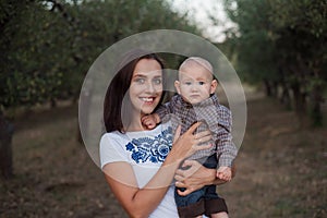 Family walk in autumn in the garden. Happy young woman with child