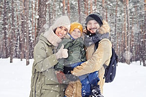 Family walk of Caucasian couple smiling and holding son on hands