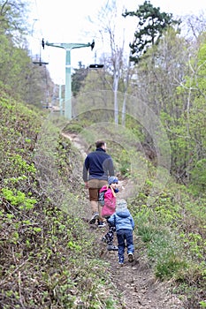 Family walk or hike through the mountain forest in early spring