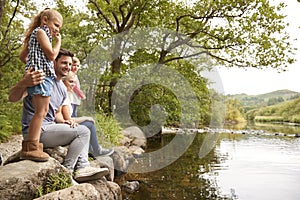 Family On Walk Looking Out Over River In UK Lake District