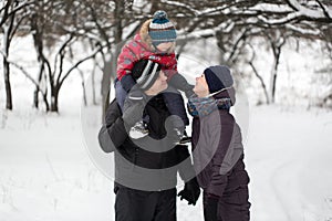 Family walk through the snow-covered forest in winter.