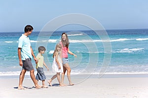 Family Walking Along Sandy Beach