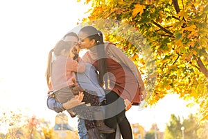 Family walking in autumn park at sunset