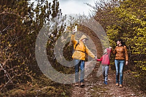 Family walking with backpacks in woods and having fun