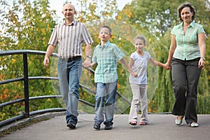 Family walking on bridge in early fall park