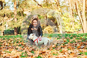 Family walking with dog in autumn park. Mother and daughter having fun together outdoors