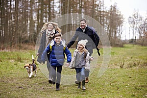 Family walking dog together in the countryside, front view