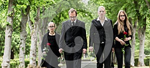 Family walking down alley at graveyard