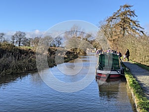 A family walking down the canal footpath by the narrowboats