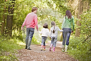 Family walking on path holding hands