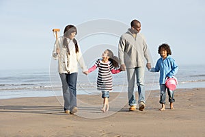 Family Walking By Sea On Winter Beach