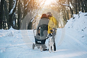 Family walking with the stroller in the winter