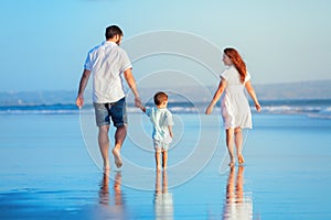 Family walking by sunset beach