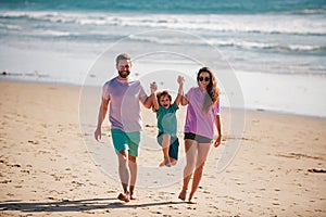 Family walking to the beach on a sunny day. Summer vacations with children.