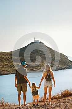 Family walking together parents with child outdoor active summer vacations lighthouse view healthy lifestyle mother and father wit