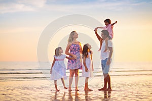 Family walking on tropical beach at sunset