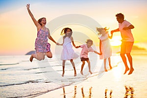 Family walking on tropical beach at sunset