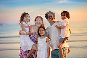 Family walking on tropical beach at sunset