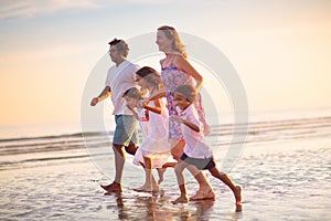 Family walking on tropical beach at sunset