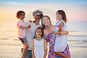 Family walking on tropical beach at sunset