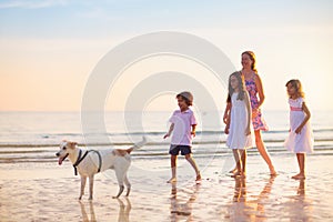 Family walking on tropical beach at sunset