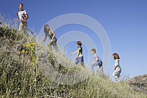 Family Walking Up Grass Slope