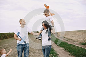 Family walks in a field and playing with toy plane