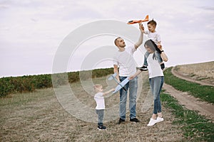 Family walks in a field and playing with toy plane