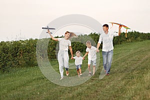 Family walks in a field and playing with toy plane