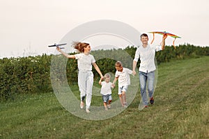 Family walks in a field and playing with toy plane