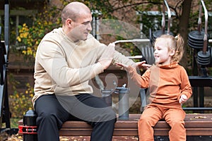 Family walks outdoors during warm hours of the day. Father and daughter love