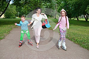 Family walks in the Park in the summer on roller skates